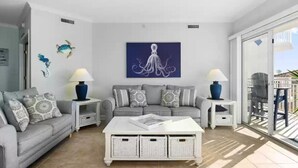 A modern living room with a grey sofa, a white coffee table, and decorative wall art.