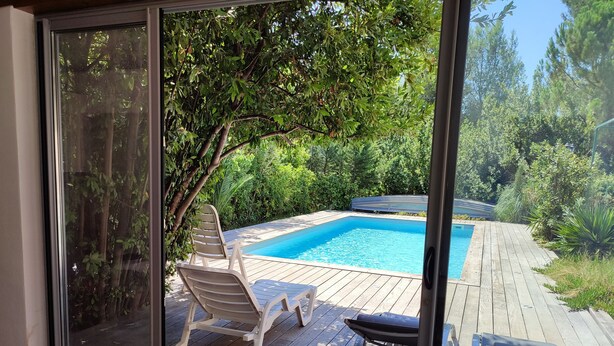 A glass door leading to a wooden deck with a pool and lounge chairs. - CHARMING VILLA WITH PRIVATE POOL - Special Summer 2026 Discount (Allauch)