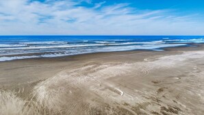 Una playa con una extensa zona arenosa y un cielo azul despejado.