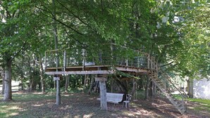 Eine Holzbrücke in bewaldeter Landschaft mit einer Bank und einer Treppe.