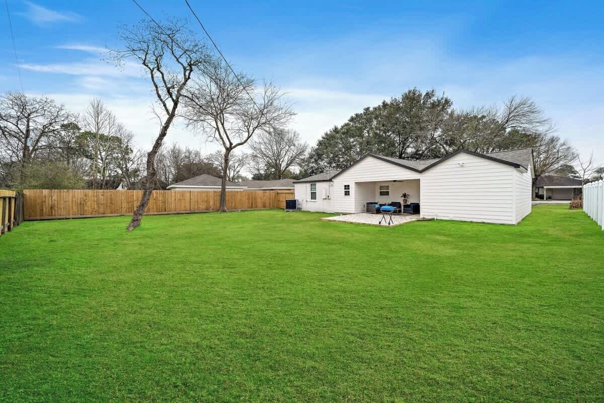 Backyard Oasis: Expansive green space perfect for outdoor games and relaxation under the Texas sun!