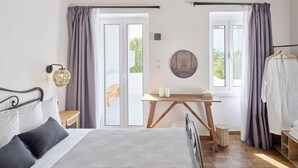 Een slaapkamer met een bed, nachtkastje, lamp en uitzicht door een glazen deur.