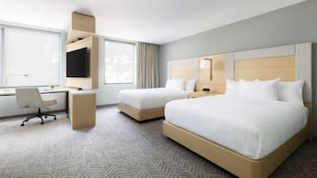 A hotel room with a bed, a desk, and a chair.