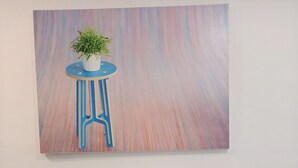 A dining table with two blue chairs, a potted plant on a blue stool, and a colorful abstract painting on the wall. - Modern, stylish apt by the sea with large balcony, sea view, close to the center (Sarandë)