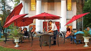 An outdoor dining area with red umbrellas, tables, and chairs. - New 3 Bdr Home - Clemson / Pendleton - Close to Everything (Pendleton)
