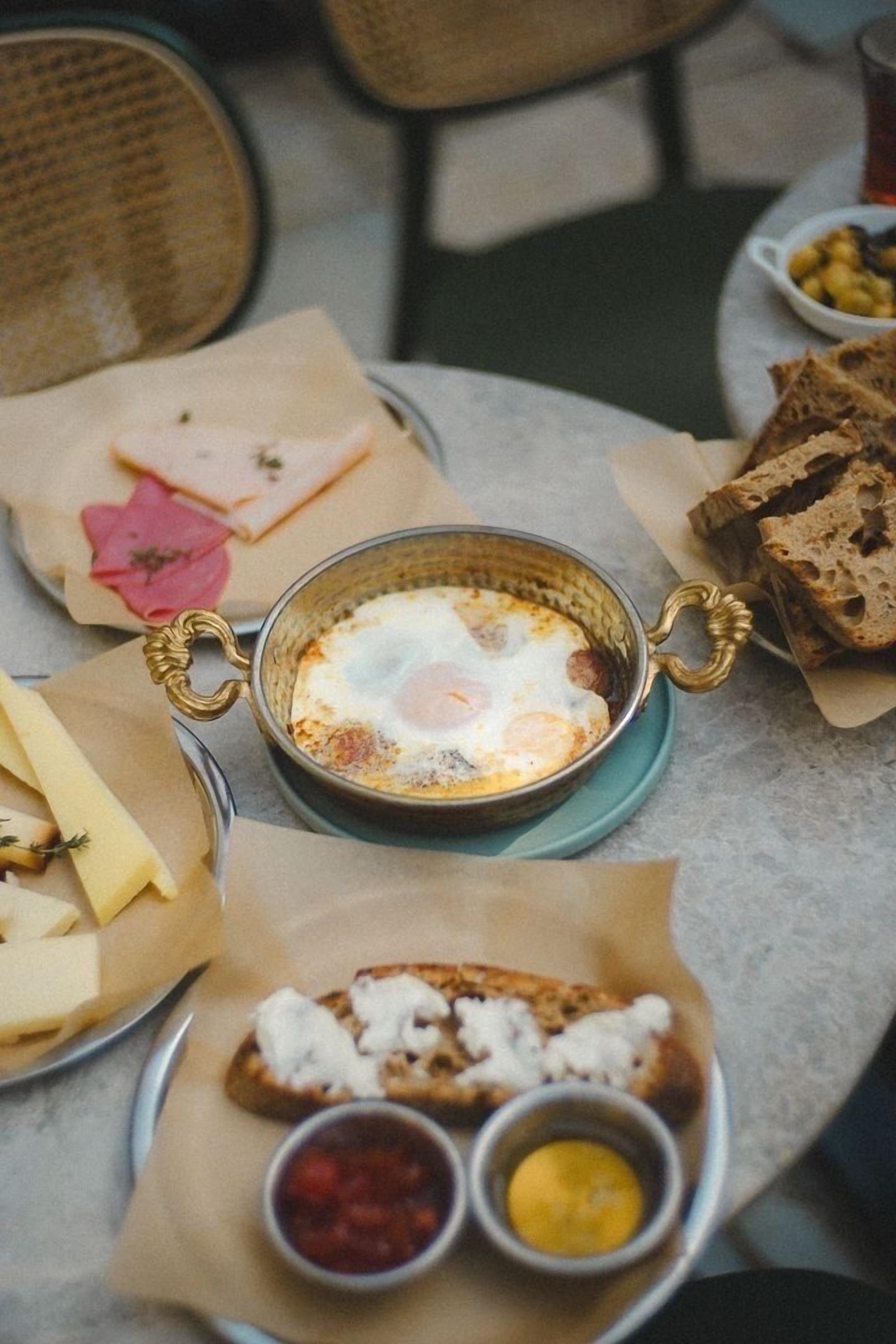 A table with a meal consisting of eggs, bread, and condiments.