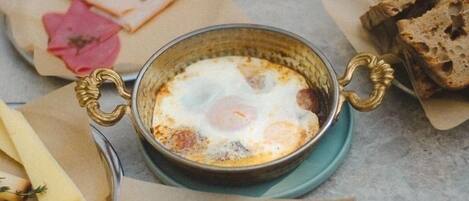 A table with a meal consisting of eggs, bread, and condiments.