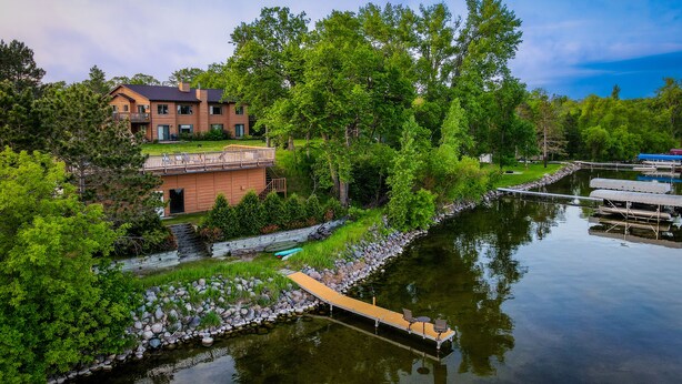 Une propriété située au bord de la rivière, comprenant une maison, un quai et une étendue d’eau calme.