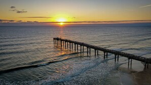 Ein Steg, der sich im Sonnenuntergang ins Meer erstreckt.