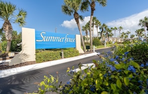 A sign for 'Summerhouse' with a clear view of the surrounding palm trees and greenery.