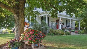 A white house with a porch, a large tree, and a welcome sign. -  Farmhouse in the Country-Perfect Place to Relax and Enjoy Family and Friends! (Lebanon)