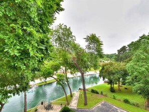 Une vue sur la rivière, avec un espace patio, des arbres et un paysage verdoyant.