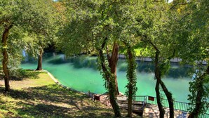A park with a lake, benches, and a wooden walkway. - River City Resorts: C202 along the Comal River (New Braunfels)