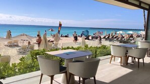 Un restaurante frente a la playa con terraza y vistas al océano.
