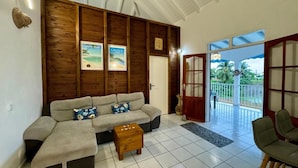 A living room with a sofa, coffee table, and a view of the outdoors through a glass door.