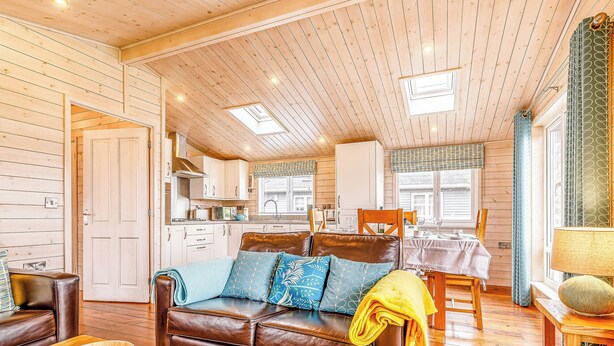 Interior acogedor de una cabaña con techo de madera, un comedor y una cocina.