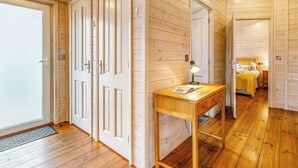 Un interior de madera con un escritorio, una cama y una puerta.