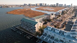 A coastal hotel with multiple floors, a dock, and a view of the adjacent beach and water. - ★★★★★ Sleeps 6,Linens &Towels✓ Free Parking✓ Sunset View✓ Smart TVs✓ Pool ✓ (Ocean City)