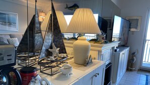 A modern kitchen with white cabinetry, a coffee maker, and decorative items like a sailboat and a large vase. - ★★★★★ Sleeps 6,Linens &Towels✓ Free Parking✓ Sunset View✓ Smart TVs✓ Pool ✓ (Ocean City)