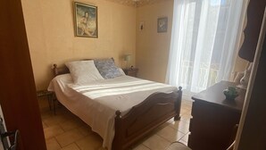 A bedroom with a bed, a desk, and a chair.