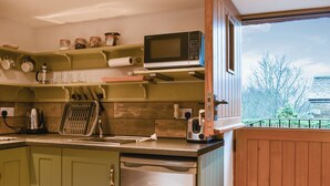 A compact kitchen with a microwave, kettle, toaster, and a dishwasher. - The Hayloft - UK37563 (Crosby Garrett, near Kirkby Stephen)