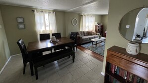 A living room with a dining table, sofa, and a bookshelf.