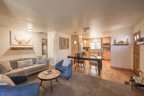 A living room with a sofa, chairs, a coffee table, and a dining area with a table and chairs.