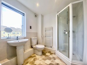 A bathroom with a sink, toilet, and glass-enclosed shower. - 4 bedroom accommodation in South Cerney (South Cerney)