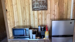 Eine Küchenzeile mit Mikrowelle, Kaffeemaschine und Kühlschrank.