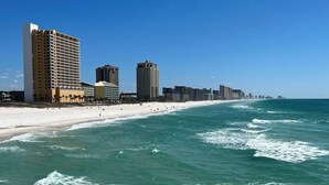 Une vue sur la plage, avec un hôtel et l’océan.