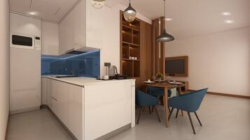 A modern kitchen with a built-in microwave, a dining area with a wooden table and blue chairs, and a pendant light above the table.
