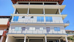 Un edificio de varios pisos con balcones, ventanas amplias y techo plano.