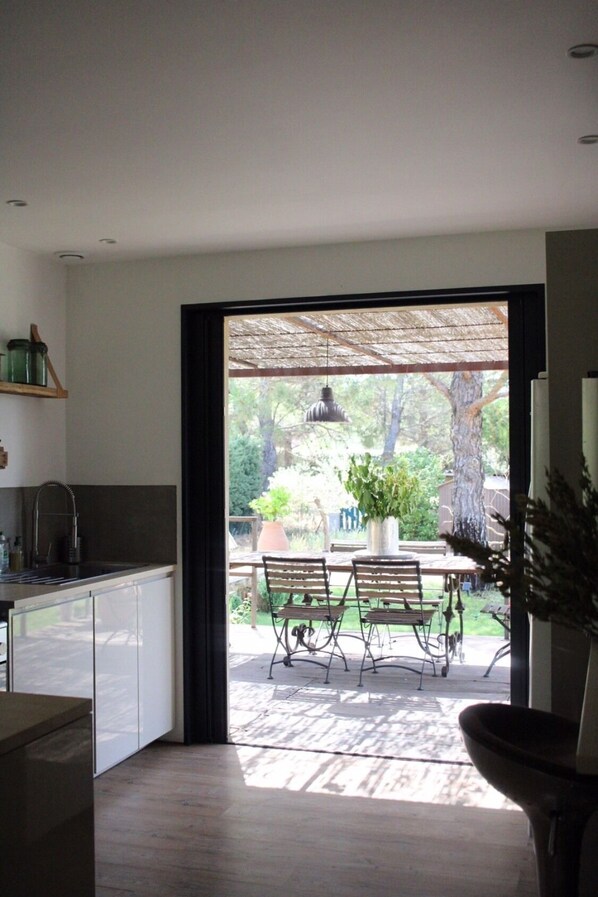A modern kitchen with a large window leading to an outdoor patio.