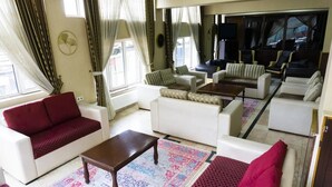 Un salón amplio con un sofá, sillones y una mesa de centro.