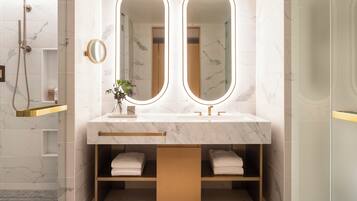 A modern bathroom with a marble vanity, dual mirrors, and a built-in shower.
