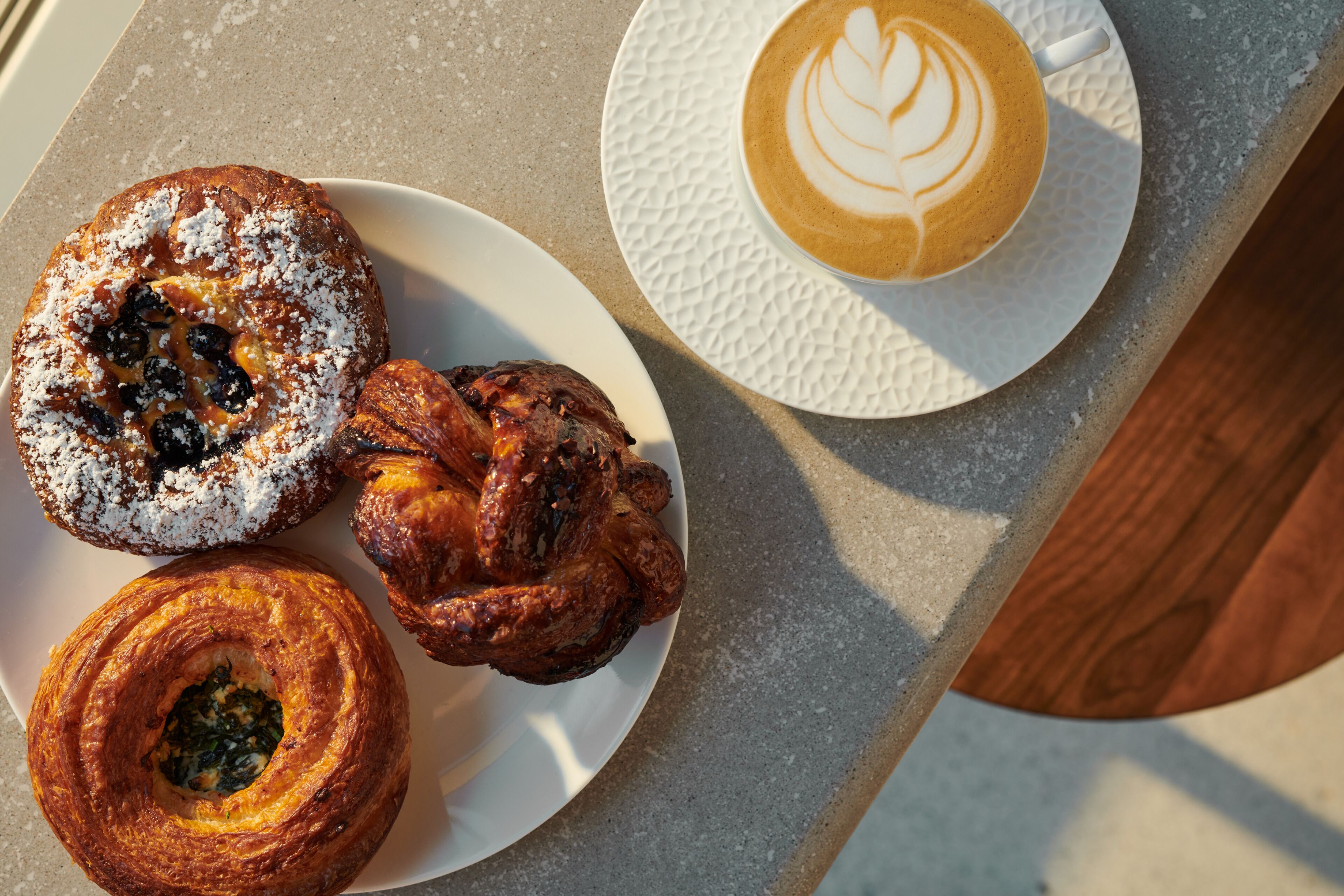 Uma mesa com doces e uma xícara de café.
