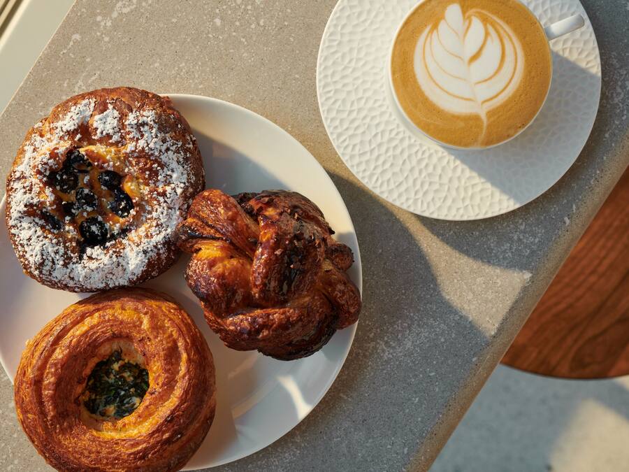 Uma mesa com doces e uma xícara de café.