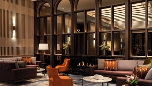 A modern living room with a fireplace, sofas, armchairs, and a coffee table.