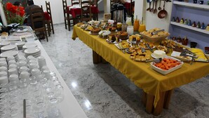 A buffet table with various food items and utensils.