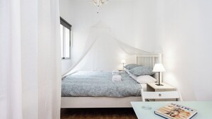 A bedroom with a bed, bedside table, lamp, and a magazine on a small table. - Home2Book Charming Apt Santa Cruz City Center (Santa Cruz de Tenerife)