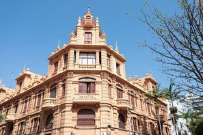 A historic building with ornate architectural details, large windows, and a prominent central tower.