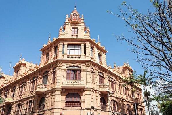 A historic building with ornate architectural details, large windows, and a prominent central tower.