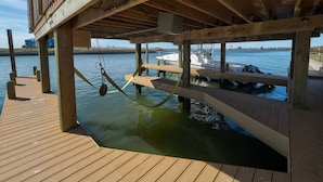 Un muelle de madera que se extiende sobre aguas tranquilas, con un barco amarrado cerca.