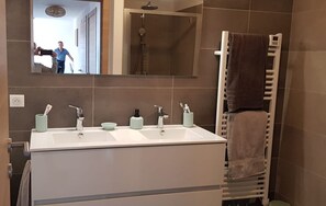 A bathroom with a white sink, two faucets, a mirror, and a towel rack. - 4-6 PERSON APARTMENT (Albitreccia)