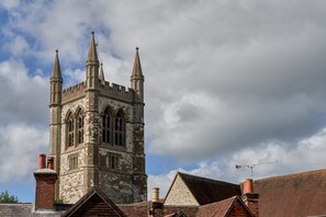 Une église historique dotée d’un haut clocher et de flèches pointues, avec de grandes fenêtres en arc et une façade en briques.