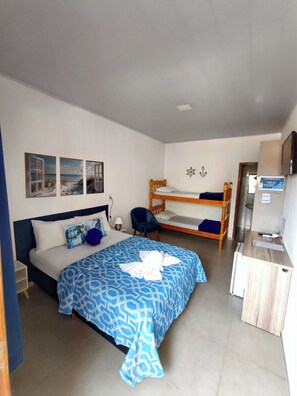 A hotel room with a bed, a desk, a chair, bunk beds, and a wall with three pictures. -  POUSADA VILLA DO MAR (Penha)