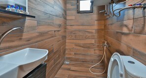 A bathroom with a wooden wall design, a sink, a toilet, and a shower area. - Kibriscik Koroglu Dag Evleri (Kibriscik)