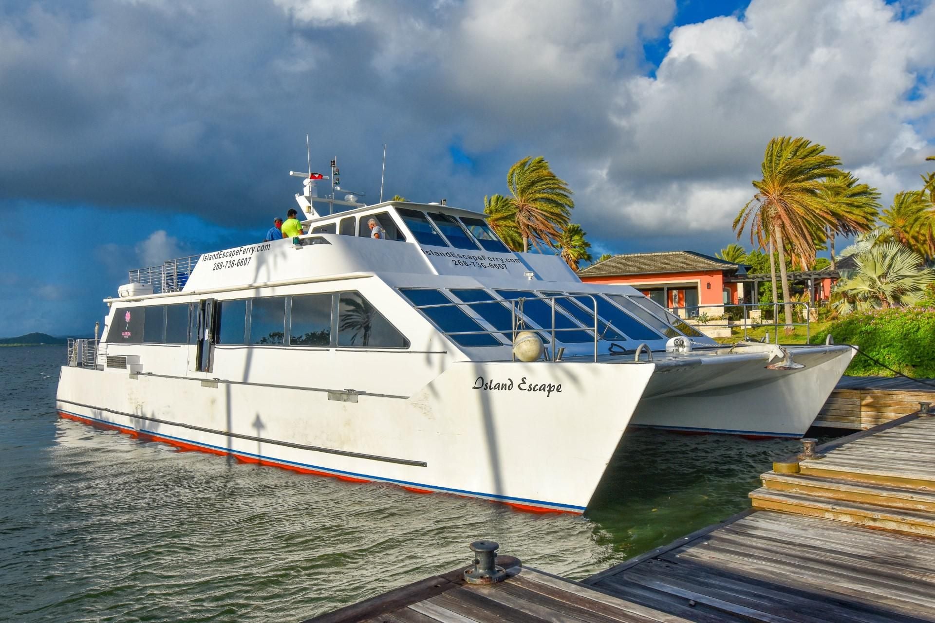 A white boat docked at a pier with a website address and contact number visible.