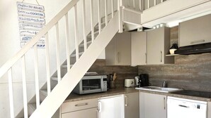 A modern kitchen with white cabinetry, a microwave, a toaster, and a dishwasher.