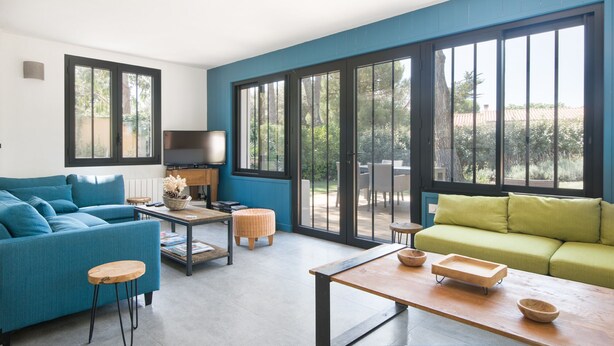 Een moderne woonkamer met een blauwgroene bank, een salontafel en een televisie.